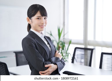  A Japanese woman in her office with her arms folded