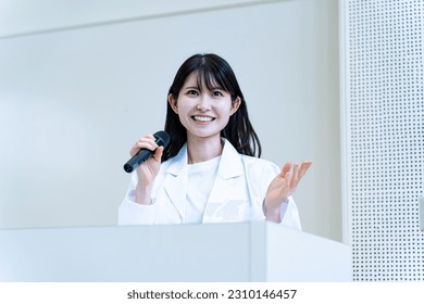 Japanese woman holding a microphone and talking - Shutterstock ID 2310146457