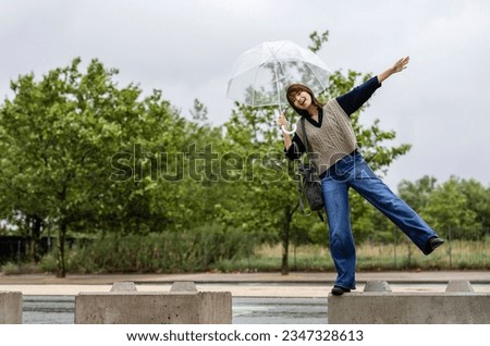 japanese woman jumping and enjoying a walk in the rain carefree