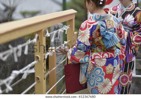 日本の神社や寺で おみくじを読む和服の女性 紙を折り畳むと 不運を招くために松や金線が付く の写真素材 今すぐ編集