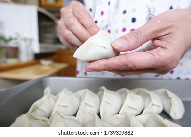 Japanese Woman Making Dumplings In The Kitchen.
