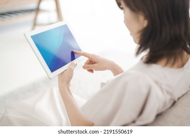 Japanese Woman Operating A Tablet Device