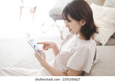 Japanese Woman Operating A Tablet Device