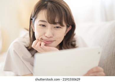 Japanese Woman Operating A Tablet Device