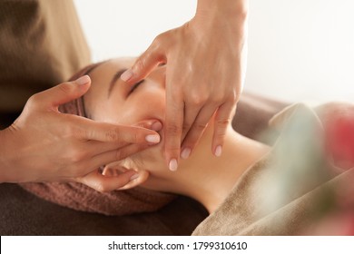 Japanese woman receiving a facial massage at an aesthetic salon - Powered by Shutterstock