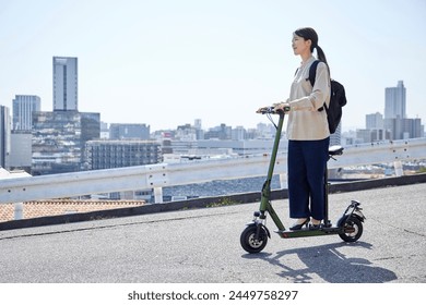 A Japanese woman traveling on an electric scooter - Powered by Shutterstock