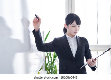 Japanese Woman Writing On A Whiteboard