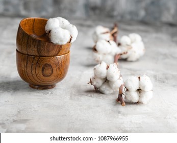Japanese Wooden sticks and wooden bowls with branch cotton flower on gray stone background. Wabi Sabi style. Horizontal. Copy space.