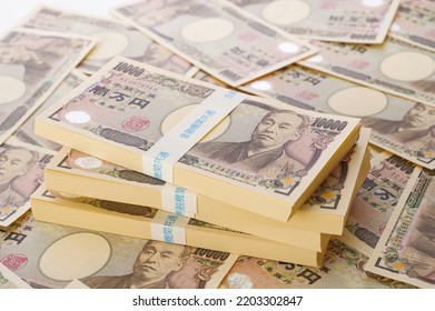 A lot of Japanese yen. 10,000 yen bills and a bundle of bills. The banknotes are written as "10,000 yen" in Japanese. The band of bills is written in the blue letter "common to financial institutions" - Shutterstock ID 2203302847
