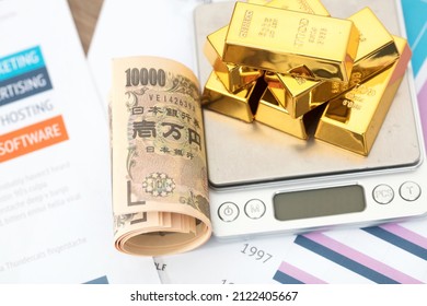 Japanese Yen Bills And A Pile Of Gold On Documents