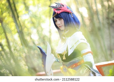 Japanese Young Woman Hunter Cosplay With Bow On Japanese Garden