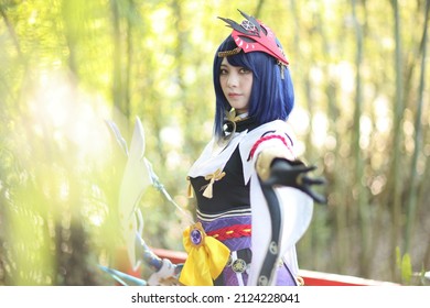 Japanese Young Woman Hunter Cosplay With Bow On Japanese Garden