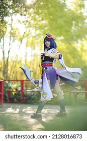 Japanese Young Woman Hunter Cosplay With Bow On Japanese Garden