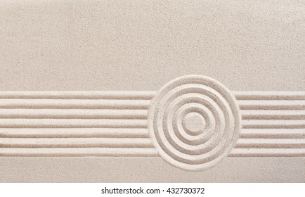 Japanese zen garden with raked sand in a minimalist pattern of parallel lines and concentric circles for meditation