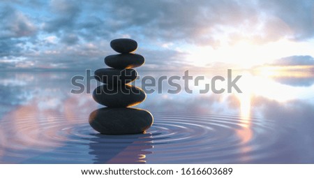 Japanese zen garden - stacks of pebbles in the wide ocean at sunset