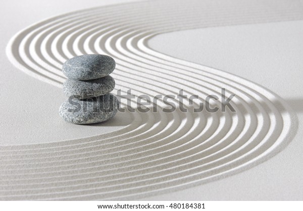 Japanese zen\
garden in white sand with stacked\
stones