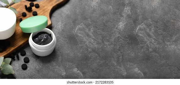 Jar Of Activated Carbon Facial Mask And Pills On Dark Background With Space For Text