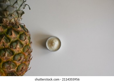 Jar of butter and pineapple on white background, top view. Pineapple oil butter texture. Food ingredient, natural cosmetics. White fat close up background. Copy space for text or logo