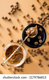 Jar With Caramel Sauce, Metal Vintage Spoon And Coffee Beans On A Brown Background. Coffee Caramel Sauce Taste