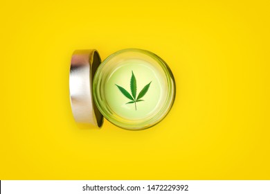 Jar With CBD Cannabis Gel Lotion On Yellow Background