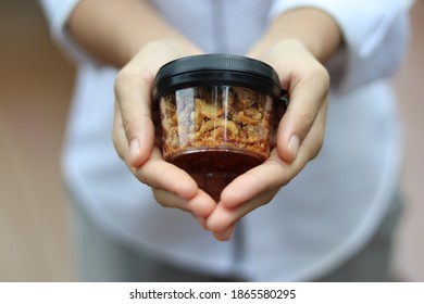 A Jar Of Chili Paste In Hand