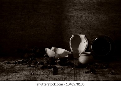 jar Clay pot broken on dark black wooden background