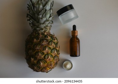 Jar of cosmetic cream and piña colada coconut and pineapple on white background. Coconut and pineapple tropic cream ads, oil full of vitamins for skin care
