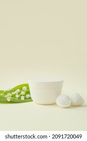 Jar Of Cream, Cotton Balls And Lily-of-the-valley Flowers On Color Background