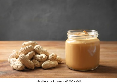 Jar with creamy peanut butter on table