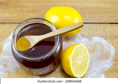 Jar Of Dark Honey A Wooden Spoon And Lemons On A Table