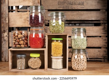 Jar food storage. Home cellar. Healthy. Canned tomatoes, lentils, split peas, legumes, nuts, rice, cereals, pasta. Ancient background, wood. - Powered by Shutterstock