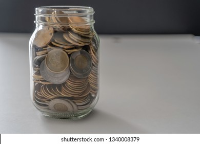 A jar full of coins on white and black background