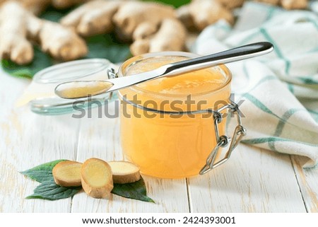 jar with ginger jam and fresh fruits on white wooden table. This jam can be used for spreading white bread, filling cakes, etc.