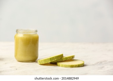 Jar With Healthy Baby Food And Zucchini On Light Background