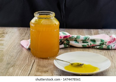 Jar Of Honey On A Wooden Background. A Spoon Of Honey On A Plate. Side View.
