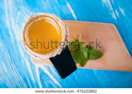 Jar of honey and spoon for honey on the blue board
