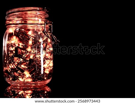 Jar with lanterns inside.
Warm colored garland on a dark background.
Beautiful lanterns in a jar with a knitted scarf.