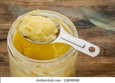 jar and measuring tablespoon of ghee - clarified butter