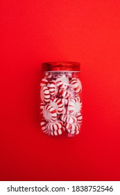 A jar of peppermint candies on red background. Christmas treat. Sweets.