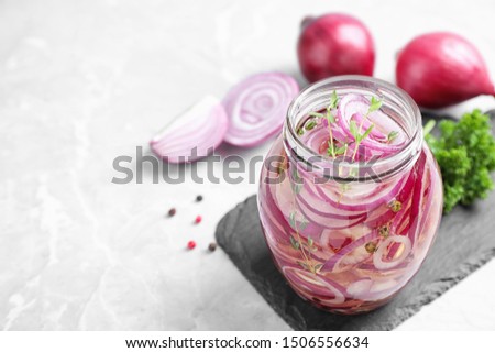 Jar of pickled onions on marble table. Space for text