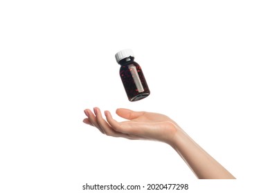 A jar of pills hovers or flying over a female hand, isolate