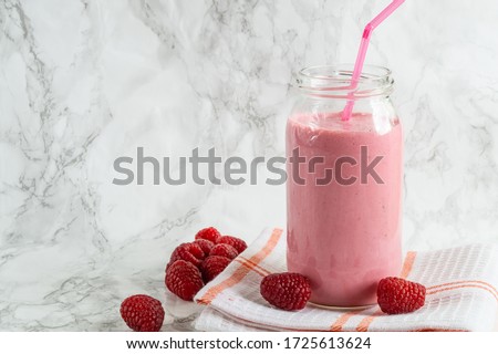 Jar with rasberry smoothie and fresh rasberry on tawel on white background.Food trend.