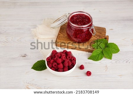 Jar of raspberry jam and fresh berries. Homemade jam