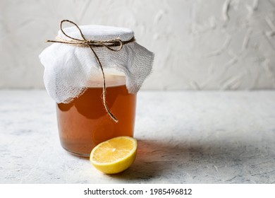 Jar of raw fermented homemade alcoholic or non alcogolic kombucha superfood. Ice tea with healthy natural probiotic with lemon on white background