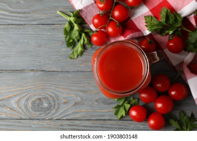 Jar of tomato juice, tomatoes and kitchen towel on wooden background