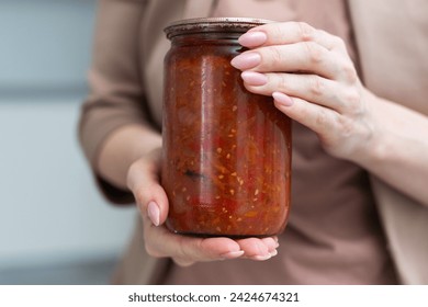 jar tomato paste in hand isolated on white background
