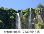 Jardin Extraordinaire, a garden in Nantes, France with a waterfall, rocks and lush vegetation.