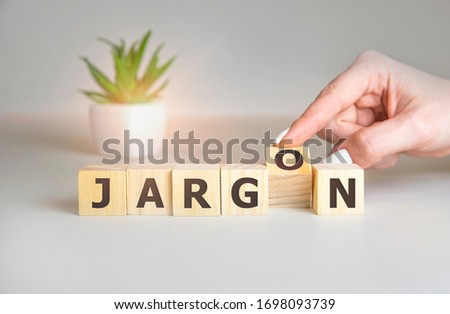 Jargon - hand holding word from wooden blocks with letters, special words and phrases jargon concept, top view on white background.