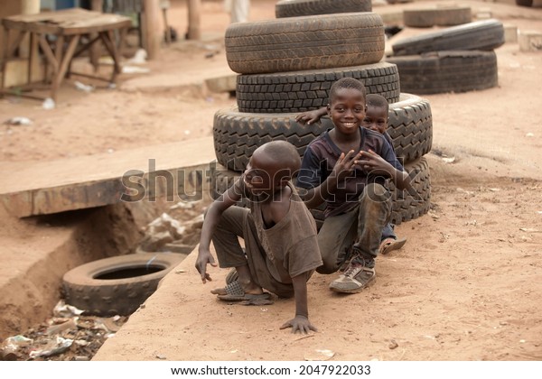 Jarra Soma, the
Gambia, Africa, June 20, 2021, photography of small african boys in
dark clothes, posing in front of a pile of used black tires,
outdoors on a sunny day