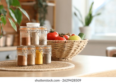 Jars with different spices on table in kitchen, closeup